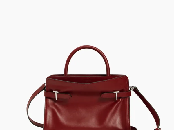 Medium structured burgundy leather handbag featuring both smooth leather and nubuck, black top handles, silver hardware, and a detachable crossbody strap.